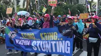 Peserta kampanye cegah stunting membawa spanduk saat berjalan di kawasan Bundaran Hotel Indonesia, Jakarta, Minggu (16/9). Peserta juga bakal memberikan penyuluhan tentang stunting ke masyarakat sekitar. (Liputan6.com/Helmi Fithriansyah)