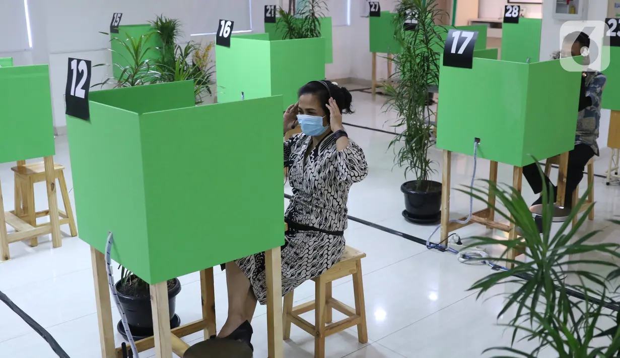 Peserta BPJAMSOSTEK berkomunikasi dengan petugas dari LAPAK ASIK (Layanan Tanpa Kontak Fisik) di Kantor Cabang Tangerang, Jumat (12/6/2020). Layanan dengan protokol kesehatan tanpa harus kontak langsung ini untuk mencegah penularan COVID-19 di masa tatanan normal baru. (Liputan6.com/Angga Yuniar)