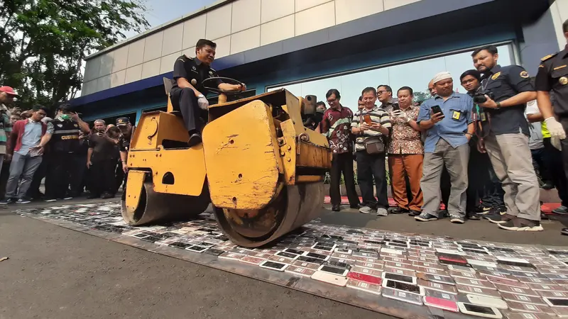 Sebanyak 2.464 unit smartphone senilai Rp 3.5 miliar sitaan Kantor Pelayanan Utama Bea dan Cukai Tipe C Soekarno Hatta, dimusnahkan dengan cara direndam semalaman di air garam dan dilindas alat berat, Selasa (8/10/2019).