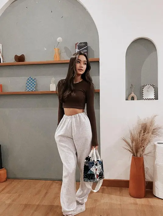 Tampil santai, cropped long sleeve top dengan jogger pants sebagai bawahan. [IG: caitlinhalderman].