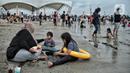 Wisatawan beristirahat saat mengisi libur Natal di Pantai Ancol, Jakarta, Minggu (25/12/2022). Kepala Komunikasi PT Pembangunan Jaya Ancol Ariyadi Eko Nugroho mengungkapkan per hari ini jumlah wisatawan di Taman Impian Jaya Ancol tembus 40.000, angka tersebut meningkat dua kali lipat dibanding libur hari biasa maupun Natal tahun 2021. (merdeka.com/Iqbal S. Nugroho)