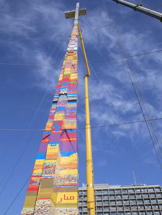 Sebuah menara LEGO sedang dibangun untuk mencoba memecahkan rekor dunia di Lapangan Rabin di Tel Aviv, Israel, Rabu (27/12). Menara setinggi 36 meter juga bertujuan untuk memecahkan Guinness World Record. (AFP Photo/Jack Guez)