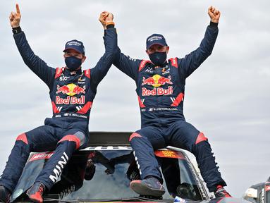 Pereli asal Prancis, Stephane Peterhanse, merayakan juara Reli Dakar 2021 di Arab Saudi, Jumat (15/1/2021). Stephane Peterhanse berhasil menambah rekor juaranya menjadi 14 kali juara Reli Dakar. (AFP/Franck FIfe)