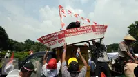 Nelayan menurunkan miniatur perahu saat melakukan aksi unjuk rasa di depan Istana Merdeka Jakarta, Kamis (21/4/2016). Dalam aksinya, mereka menolak reklamasi teluk Jakarta dan menolak penggusuran pemukiman nelayan. (Liputan6.com/Helmi Fithriansyah)