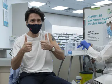 Perdana Menteri Kanada Justin Trudeau (kiri) mengacungkan jempol usai menerima vaksinasi COVID-19 AstraZeneca di Ottawa, Kanada, Jumat (23/4/2021). Trudeau disuntik vaksin AstraZeneca dalam upaya meyakinkan publik Kanada soal keamanannya. (Adrian Wyld/The Canadian Press via AP)