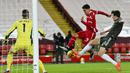 Bek Manchester United, Harry Maguire, berusaha menghalau tendangan striker Liverpool, Roberto Firmino,  pada laga Liga Inggris di Stadion Anfield, Minggu (17/1/2021). Kedua tim bermain imbang 0-0. (Paul Ellis/Pool via AP)