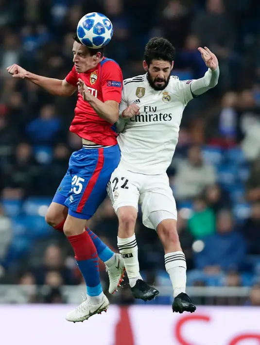 Pemain CSKA Moscow Kristijan Bistrovic melompat untuk berebut bola dengan bola gelandang Real Madrid, Isco pada laga terakhir Grup G Liga Champions di Santiago Bernabeu, Rabu (12/12). Real Madrid dipecundangi CSKA Moscow 0-3. (AP/Manu Fernandez)