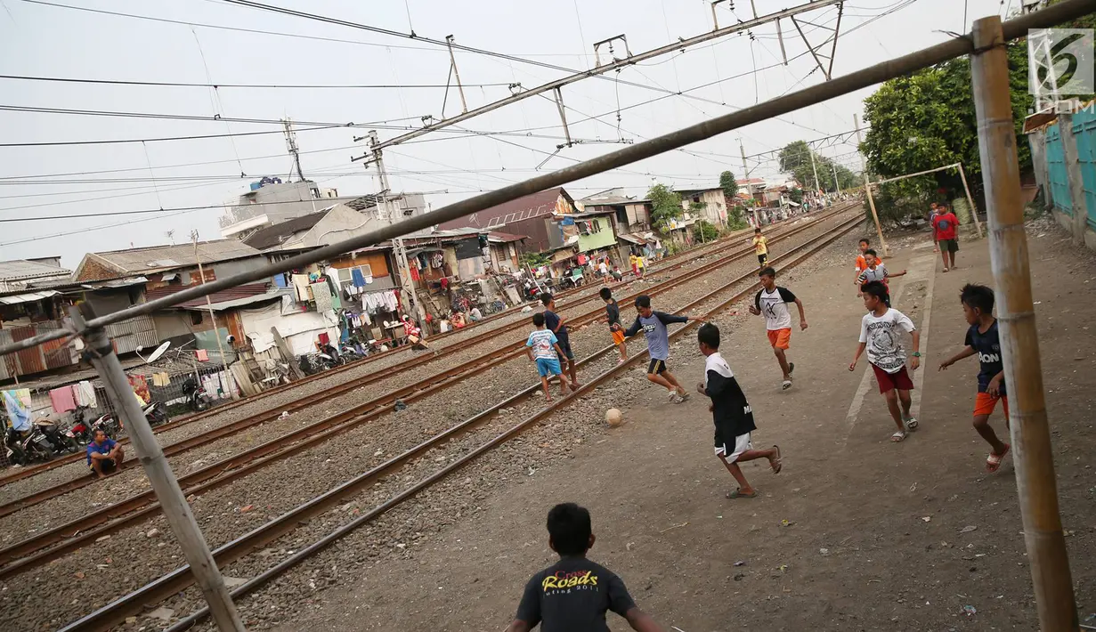 Suasana di pinggir rel kereta api di kawasan Kemayoran, Jakarta, Senin (24/7). Minimnya lahan bermain menyebabkan anak-anak terpaksa bermain di lokasi tersebut, meskipun berbahaya bagi keselamatan. (Liputan6.com/Immanuel Antonius)