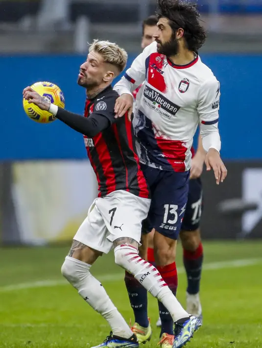 Gelandang AC Milan, Samu Castillejo berebut bola dengan pemain Crotone, Sebastiano Luperto pada pertandingan lanjutan Liga Serie A Italia di stadion San Siro di Milan, Italia, Minggu (7/2/2021). AC Milan menang telak atas Crotone 4-0. (AP Photo/Antonio Calanni)