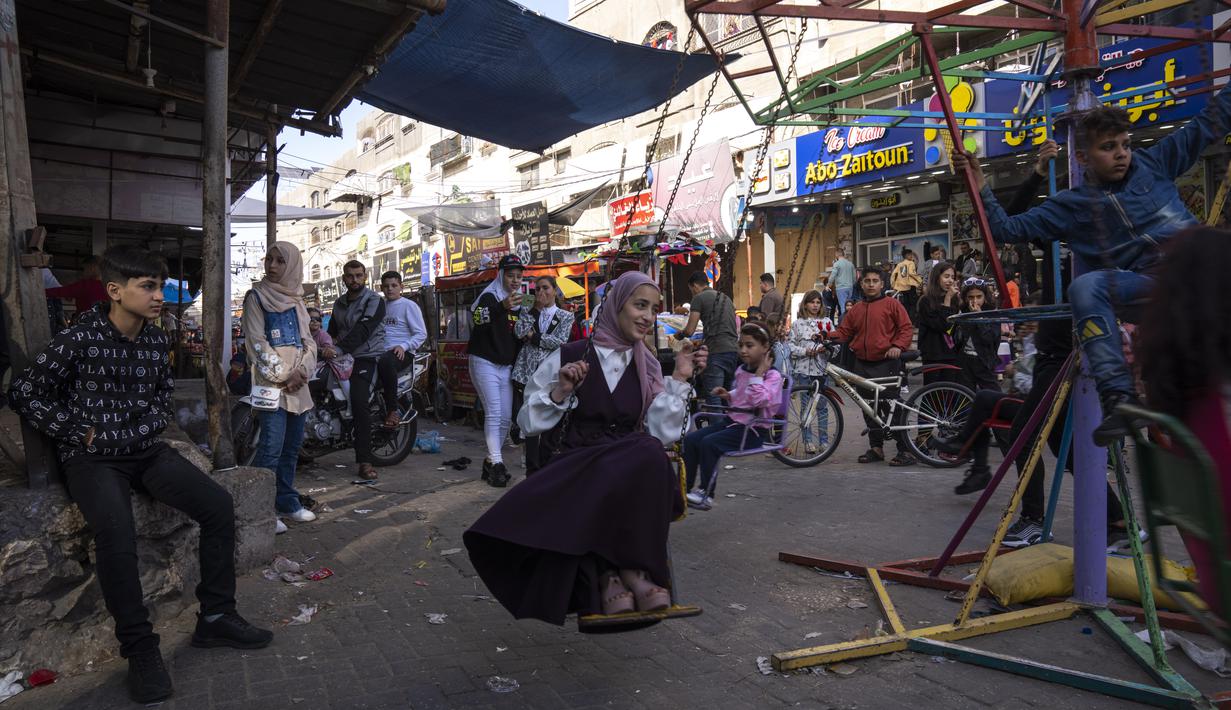 Senyum ceria terpancar dari wajah anak-anak Palestina saat bermain merayakan Idul Fitri 1444 Hijriah. (AP Photo/Fatima Shbair)