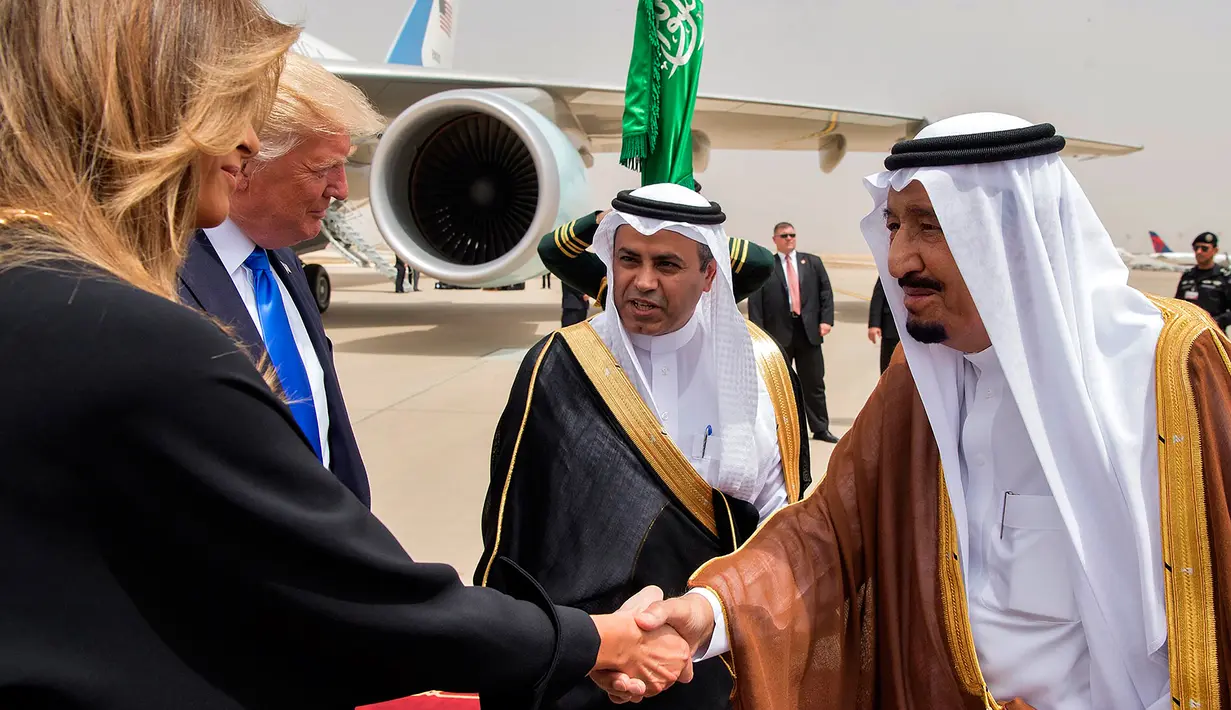 Melania Trump (kiri) berjabat tangan dengan Raja Arab Saudi Salman bin Abdulaziz al-Saud saat di Bandara Internasional Raja Khalid di Riyadh (20/5). (AFP/Saudi Royal Palace/Bandar Al-Jalou)