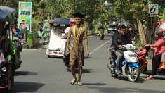 Mahasiswa UniversItas Gorontalo, Indra Nodu melakukan aksi jalan kaki dari kampus ke rumahnya di Desa Posso, Gorontalo Utara, 4 Agustus 2018. Aksi itu untuk memenuhi nazarnya karena telah berhasil menyelesaikan studi S1. (Liputan6.com/Arfandi Ibrahim)