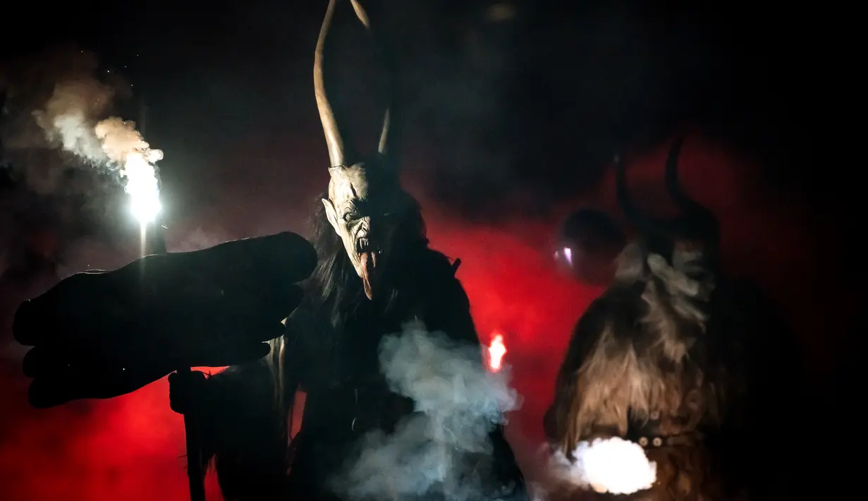 Partisipan berpakaian seperti Krampus, makhluk setengah iblis, saat ambil bagian dalam parade di kota Podkoren, Slovenia, Jumat (30/11). Tradisi natal ini juga dilakukan di beberapa negara seperti Austria, Jerman, Hungaria dan Ceko. (Jure Makovec/AFP)