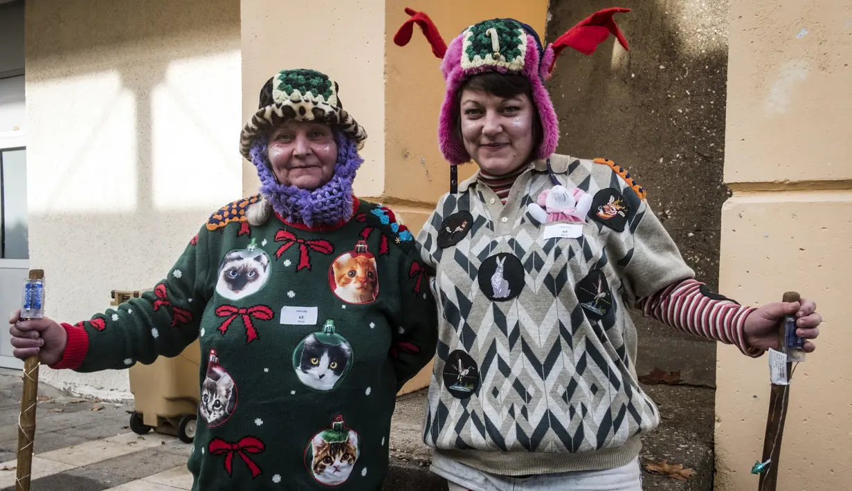 Anne dan putrinya Charline saat berlangsungnya Kejuaraan Dunia Sweater Terjelek di kota Albi, Prancis pada 1 Desember 2018. Peserta yang mengikuti kompetisi, terbagi dalam kategori anak-anak, perorangan, dan keluarga. (ERIC CABANIS / AFP)