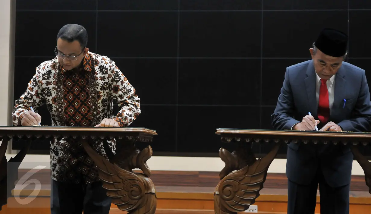 Mendikbud yang baru Muhadjir Effendy (kanan) bersama mantan Mendikbud Anies Baswedan saat menandatangani surat serah terima jabatan di Jakarta, Rabu (27/7). (Liputan6.com/JohanTallo)