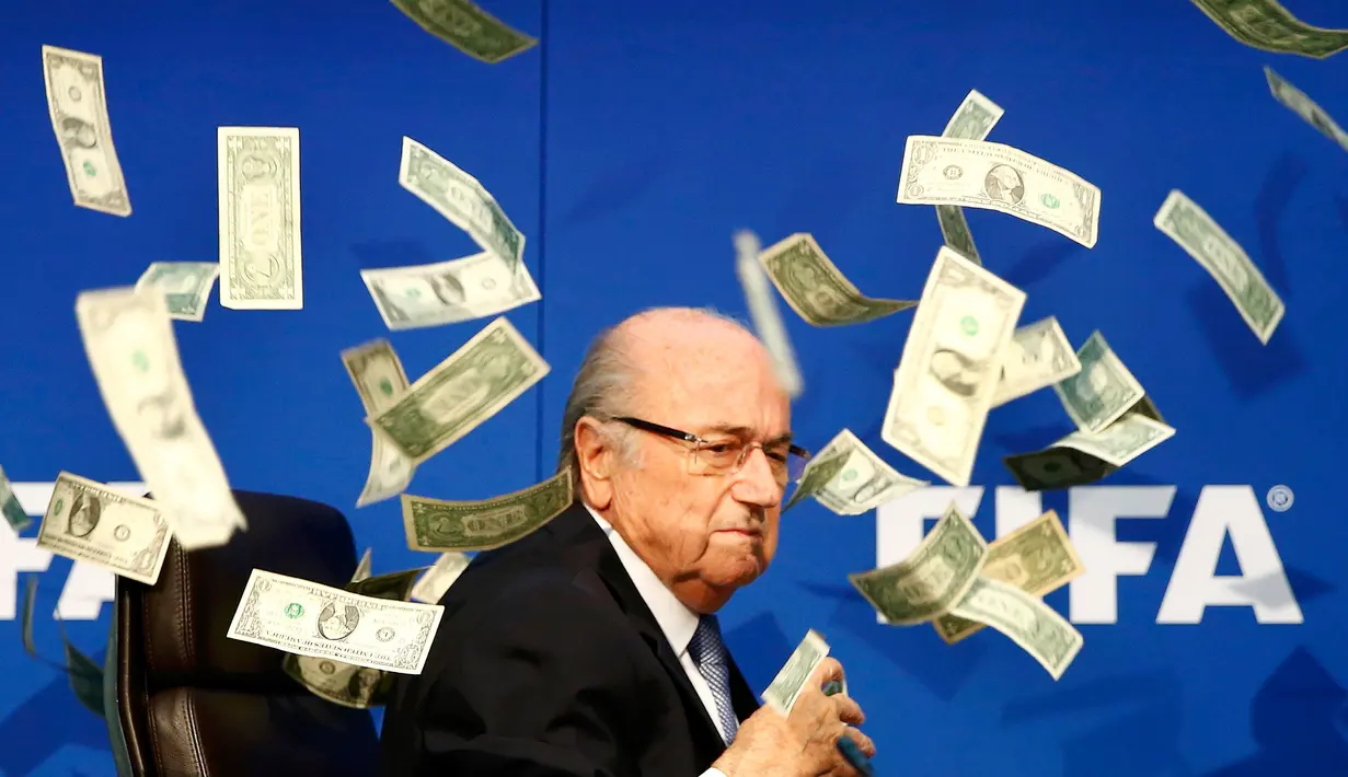 Komedian Inggris, Lee Nelson melempar uang kertas ke arah Sepp Blatter di markas FIFA di Zurich, Swiss (20/7/2015). Kedatangan Nelson membuat jumpa pers tertunda beberapa saat. (REUTERS/Arnd Wiegmann)