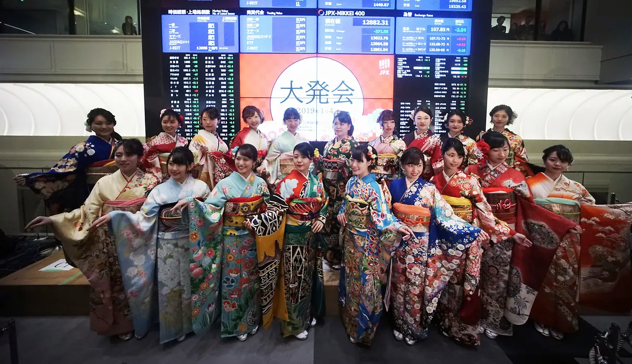 Sejumlah wanita berbaju Kimono berpose depan papan harga saham saat pembukaan Bursa Efek Tokyo di Tokyo, Jepang, Jumat (4/1). Sederet gadis cantik berpakaian Kimono turut hadir meramaikan acara tersebut. (AP Photo/Eugene Hoshiko)