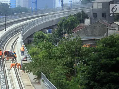 Pekerja menyelesaikan pembangunan LRT (Light Right Transit) Jabodebek di kawasan Kampung Makasar, Jakarta, Sabtu (26/10/2019). LRT akan diuji coba pada awal November 2019. (Liputan6.com/JohanTallo)