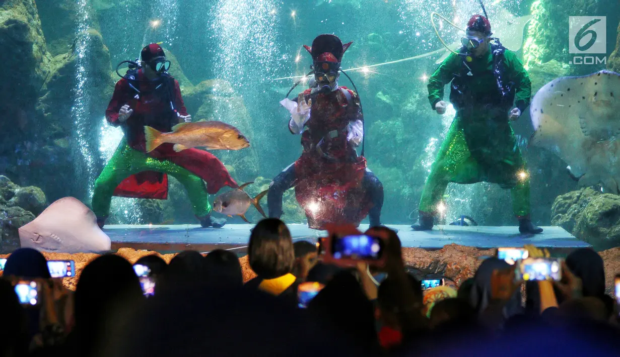 Pengunjung menyaksikan pertunjukkan barongsai di dalam air di Seaworld Ancol, Jakarta, Minggu (3/2). Pertunjukan dalam rangka memeriahkan Tahun Baru Imlek 2570 tersebut mengangkat tema "The Legend of 12 Shio". (Liputan6.com/Johan Tallo)