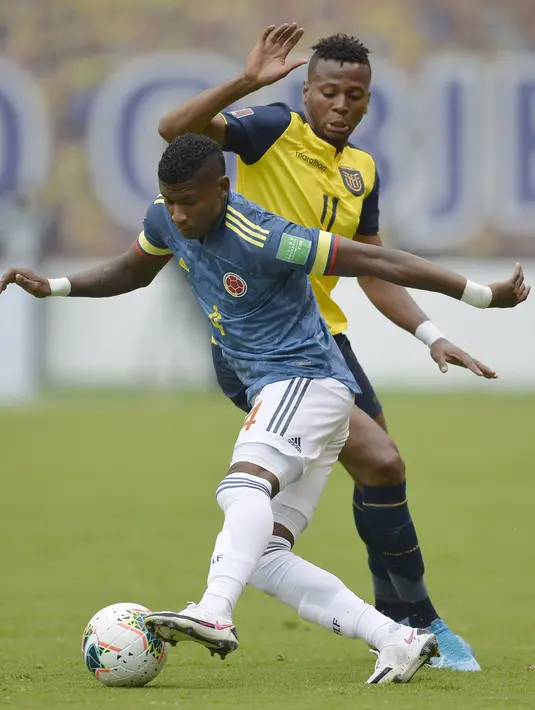 Bek Kolombia, Luis Orejuela membawa bola dari kawalan penyerang Ekuador, Michael Estrada pada pertandingan kualifikasi Piala Dunia 2022 di Quito, Ekuador, Selasa (17/11/2020). Ekuador menang telak atas Kolombia 6-1. (Rodrigo Buendia, Pool via AP)