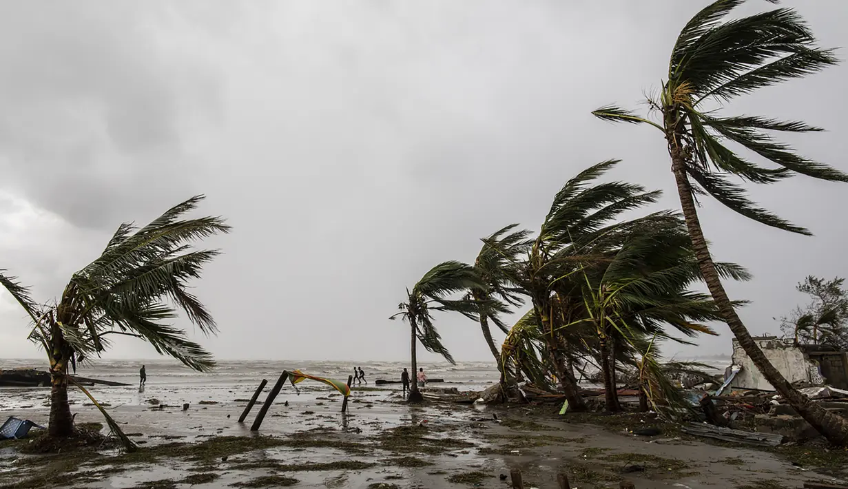 Orang-orang berjalan di pantai setelah lewatnya Badai Iota di Bilwi, Nikaragua (17/11/2020). Badai Iota telah menewaskan sedikitnya sembilan orang saat menghancurkan rumah, menumbangkan pohon dan menggenangi air. (AFP/Inti Ocon)