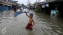 Seorang anak bergaya saat banjir melanda kawasan Rawa Buaya, Jakarta, Minggu (28/2/2016). Rawa Buaya menjadi kawasan yang mengalami banjir terparah hingga mencapai 1 meter. (Liputan6.com/Gempur M Surya)