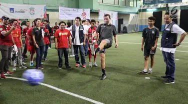 Legenda Liverpool Vladimir Smicer (tengah) didampingi Manajemen AXA Mandiri Hartono dan Preskom AXA Mandiri Agus Haryoto Widodo menendang bola pada pembukaan sharing and learning di Grand Futsal, Jakarta, Jumat (8/2). (Liputan6.com/Fery Pradolo)