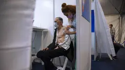 Benno Abramovich (98) menerima vaksin virus corona COVID-19 dari staf medis di Pusat Vaksinasi COVID-19, Tel Aviv, Israel, Minggu (3/1/2021). Israel memiliki tingkat 11,55 dosis vaksinasi per 100 orang. (AP Photo/Oded Balilty)