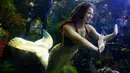 Putri duyung Hales Parcels berinteraksi dengan anak-anak yang menonton penampilannya di Virginia Aquarium di Virginia Beach (3/4). Hales Parcels tampil berenang menggunakan pakaian ala putri duyung. (AP Photo/Steve Helber)