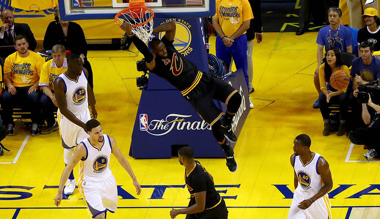 Pebasket Cleveland Cavaliers, LeBron James, melakukan dunk saat gim ketujuh final NBA melawan Golden State Warriors. Pada laga itu LeBron menjadi bintang dengan mencetak 27 poin. (AFP/Ezra Shaw)