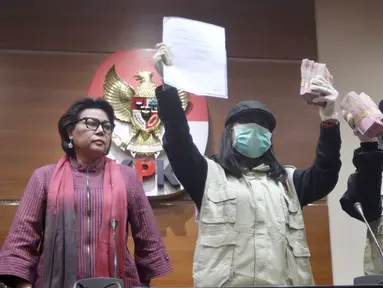 Wakil Ketua KPK, Basaria Panjaitan dan dua penyidik menunjukkan barang bukti Operasi Tangkap Tangan (OTT) uang Rp 500 juta di Gedung KPK Jakarta, Sabtu (14/7). KPK menetapkan dua tersangka di rumah dinas Menteri Sosial. (Liputan6.com/Johan Tallo)
