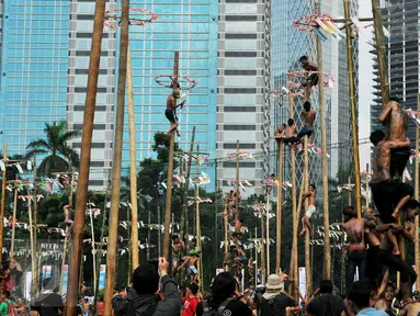 Warga mengikuti lomba panjat pinang massal dalam rangka merayakan HUT Kemerdekaan RI ke-71 di lapangan ex Golf Driving Range Senayan, Jakarta, Rabu (17/8). Panitia menyediakan ratusan batang pohon dengan sejumlah hadiah. (Liputan6.com/Gempur M Surya)