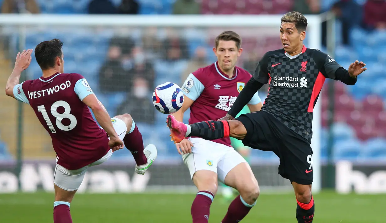 Gelandang Liverpool, Roberto Firmino (kanan) berebut bola dengan gelandang Burnley, Ashley Westwood dalam laga lanjutan Liga Inggris 2020/2021 pekan ke-37 di Turf Moor, Burnley, Rabu (19/5/2021). Liverpool menang 3-0 atas Burnley. (AFP/Alex Livesey/Pool)