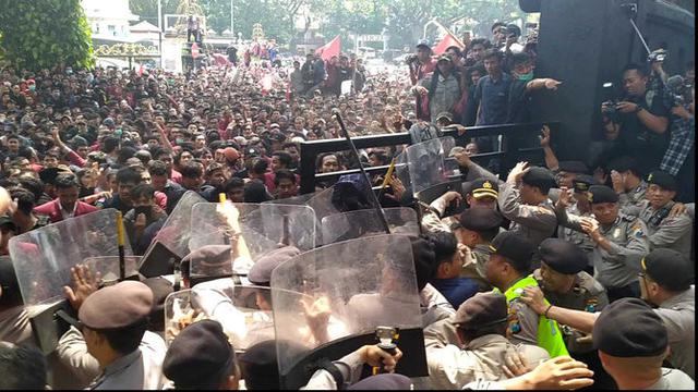 Massa unjuk rasa dihalau polisi dengan semprotan water canon di depan Gedung DPRD Malang. (Merdeka/Darmadi Sasongko)