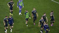 Para pemain Skotlandia meningglkan lapangan Stadion Allianz Arena usai dilumat Jerman 1-5 pada laga pembuka Euro 2024, Sabtu (15/6/2024) dini hari WIB. (AP Photo/Sergei Grits)