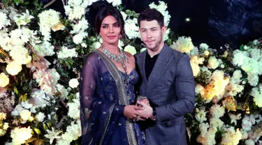 Pasangan aktris Bollywood Priyanka Chopra dan musisi Nick Jonas berpose untuk resepsi pernikahan mereka di Mumbai, India, Rabu (19/12). Resepsi kedua Priyanka Chopra dan Nick Jonas hanya mengundang kerabat dan teman dekat. (AP/Rajanish Kakade)