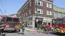 Petugas pemadam kebakaran berdiri di lokasi kebakaran di Hazleton, Pennsylvania (26/7/2019). Restoran dan apartemen Prestigio rusak dilalap api. (Warren Ruda/Hazleton Standard-Speaker via AP)
