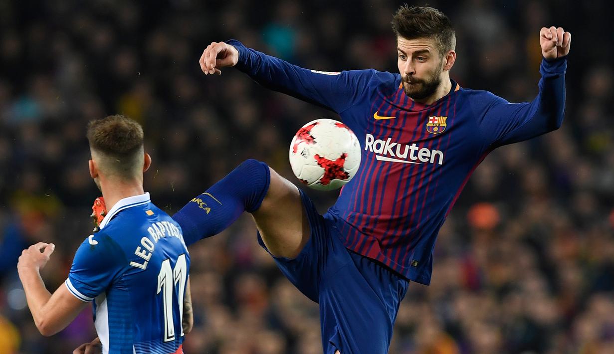 Pemain Barcelona, Gerard Pique berebut bola dengan pemain Espanyol, Leo Baptistao pada laga leg kedua perempat final Copa del Rey di Camp Nou, Kamis (25/1). Tiket semifinal berhasil diraih Barcelona usai mengalahkan Espanyol 2-0. (AFP PHOTO/LLUIS GENE)