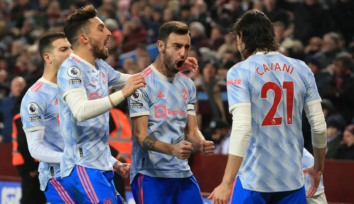 Gelandang Manchester United, Bruno Fernandes (tengah) merayakan dengan rekan satu timnya usai mencetak gol ke gawang Aston Villa pada pertandingan lanjutan Liga Inggris di Villa Park di Birmingham, Inggris, Minggu (16/1/2022). Bruno Fernandes mencetak dua gol dipertandingan ini. (AFP/Lindsey Parnaby