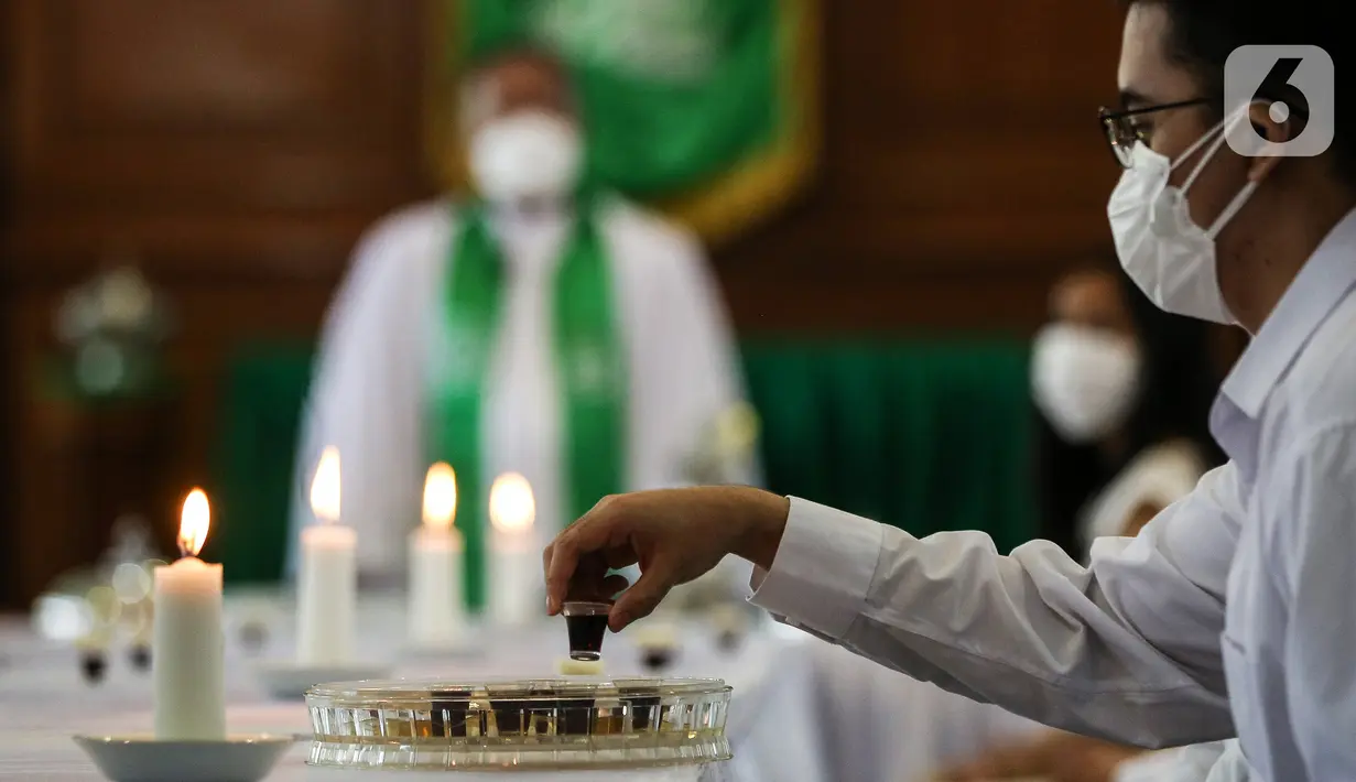 Jemaat melakukan Ibadah Perjamuan Kudus tatap muka pertama di Gereja Protestan Indonesia Bagian Barat (GPIB) Effatha, Jakarta, Minggu (3/10/2021). Ibadah berlangsung dengan menerapkan protokol kesehatan yang ketat. (Liputan6.com/Johan Tallo)