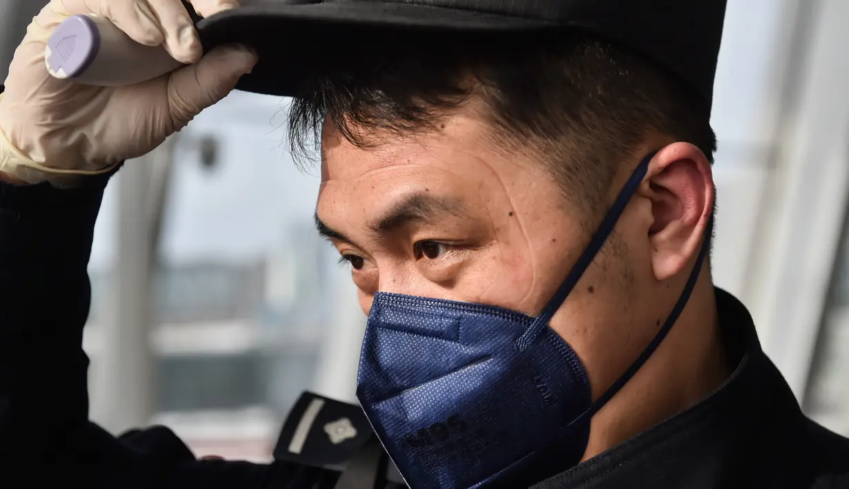 Wu Shengzao, seorang personel kepolisian, mencopot kacamata pelindung usai memeriksa kondisi seorang penumpang di Bandara Internasional Daxing di Beijing, ibu kota China, pada 1 Februari 2020. (Xinhua/Peng Ziyang)