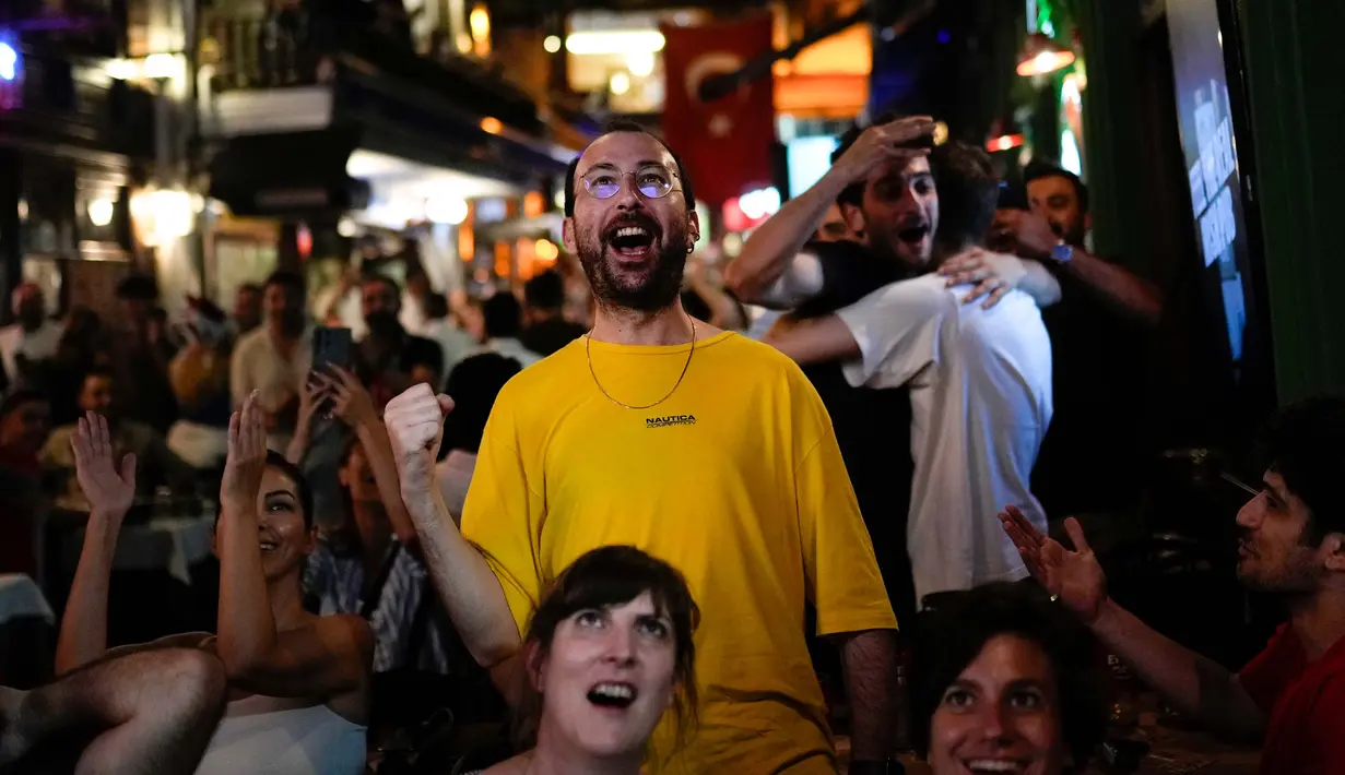 Ratusan suporter yang melalukan nonton bareng di distrik Beyoglu, Istanbul berpesta menyambut kemenangan Turki atas Austria. (AP Photo/Francisco Seco)