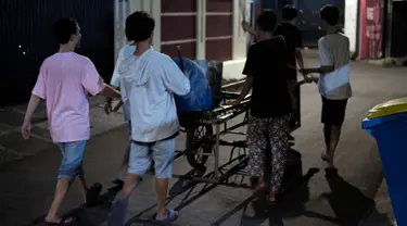 Foto yang diambil pada 19 Mei 2018, para pemuda bernyanyi dan memukul drum berkeliling sekitar lingkungan mereka di Jakarta. Kegiatan tersebut merupakan tradisi selama bulan ramadan membangunkan warga untuk sahur. (AFP PHOTO/BAY ISMOYO)