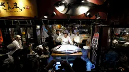 Kiyoshi Kimura berpose memegang pedang sebelum memotong tuna sirip biru dengan berat 200 kg di Tsukiji, Tokyo, Jepang, Selasa (5/1). Kimura mendapatkan tuna sirip biru dengan harga 14 juta yen atau Rp 1,6 miliar. (REUTERS/Toru Hanai)