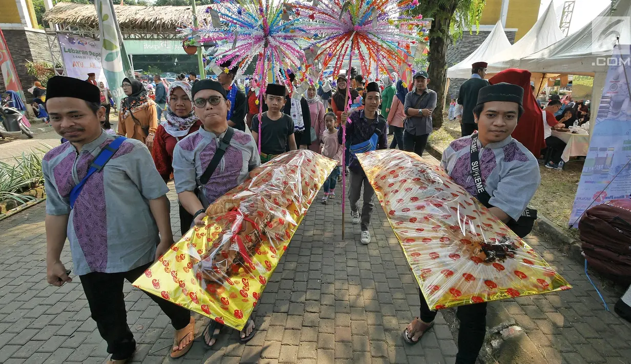 Warga membawa roti buaya saat pawai pada Lebaran Orang Depok di Sawangan, Depok, Jawa Barat, Minggu (7/7/2019). Lebaran Orang Depok baru pertama kali diadakan acara tersebut untuk melestarrikan budaya dan sebagai ajang silaturahmi warga Depok. (Liputna6.com/Herman Zakharia)
