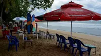 Vendor menyiapkan tempat duduk untuk wisatawan di pantai Kuta di pulau resor Bali (4/10/2021). Kebijakan diambil menyusul semakin turunnya kasus positif Covid-19 di Indonesia. (AFP/Sony Tumbelaka)