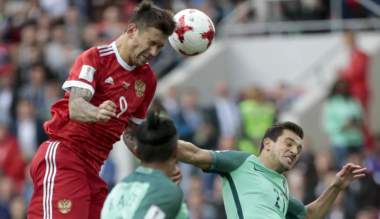 Pemain Rusia, Fedor Smolov (atas) berebut bola dengan para pemain Portugal pada laga grup A Piala Konfederasi 2017 di Spartak Stadium, Moscow, (21/6/2017). Portugal menang 1-0. (AP/Ivan Sekretarev)