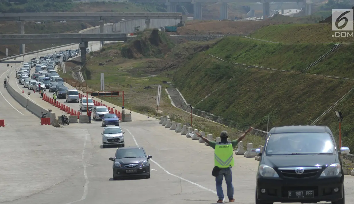 Petugas dari PT Waskita Karya mengatur kendaraan saat pola buka tutup pada ruas tol fungsional Bogor-Sukabumi di Cigombong, Bogor (16/6). Kemacetan terjadi sepanjang lebih dari lima kilometer pada jalan arteri Ciawi-Sukabumi. (Merdeka.com/Arie Basuki)