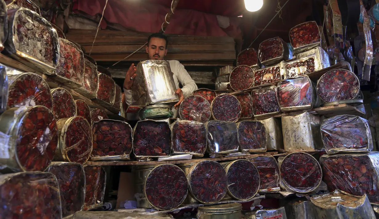 Pedagang menunggu pembeli menjelang bulan suci Ramadan di pasar kota tua Sanaa, Yaman, Sabtu (18/4/2020). Di tengah pandemi virus corona COVID-19, umat muslim di Yaman dilarang untuk menggelar buka puasa bersama hingga salat berjemaah di masjid. (Mohammed HUWAIS/AFP)