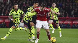 Pemain Arsenal, William Saliba, berebut bola dengan pemain Nottingham Forest, Chris Wood, dalam laga Premier League 2023/2024 pekan 22 di Stadion City Ground, Rabu (31/1/2024). (AP Photo/Rui Vieira)